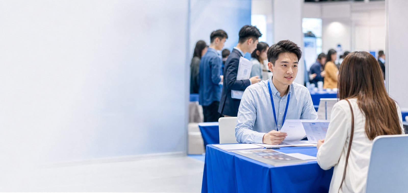 招聘会现场实拍：求职者在展位前排队咨询与查看岗位信息